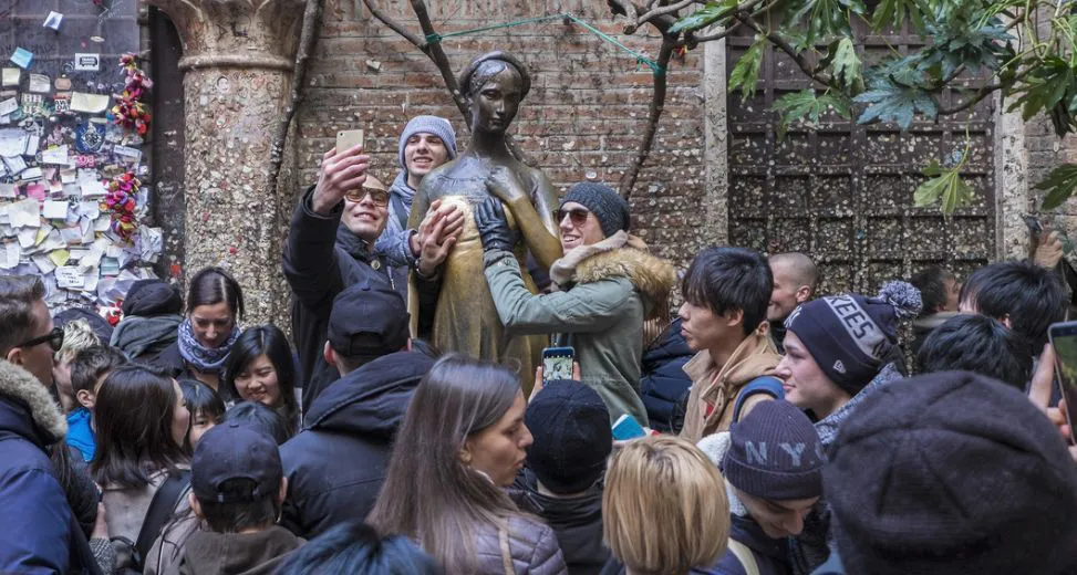 Turistas tocando la estatua de Julieta