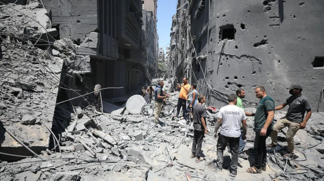 Palestinos sobre escombros de edificios destruidos tras los ataques israelíes en Gaza